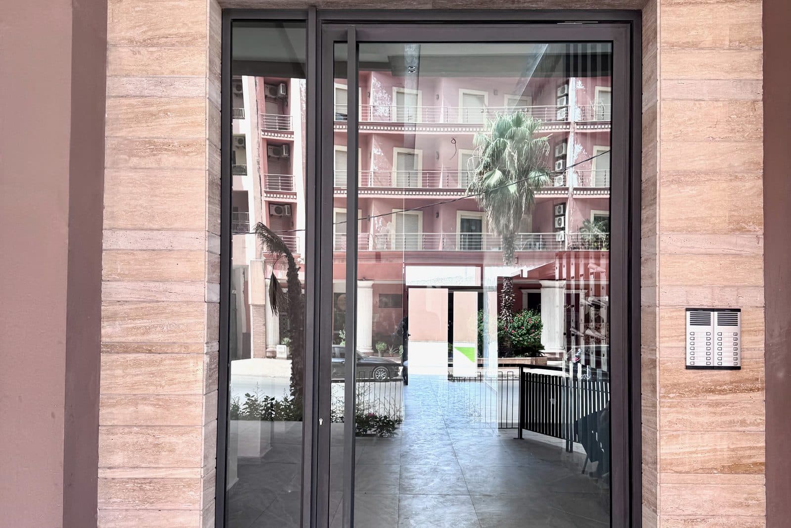 Entrée d'une résidence à Marrakech, porte vitrée donnant sur la cour intérieure