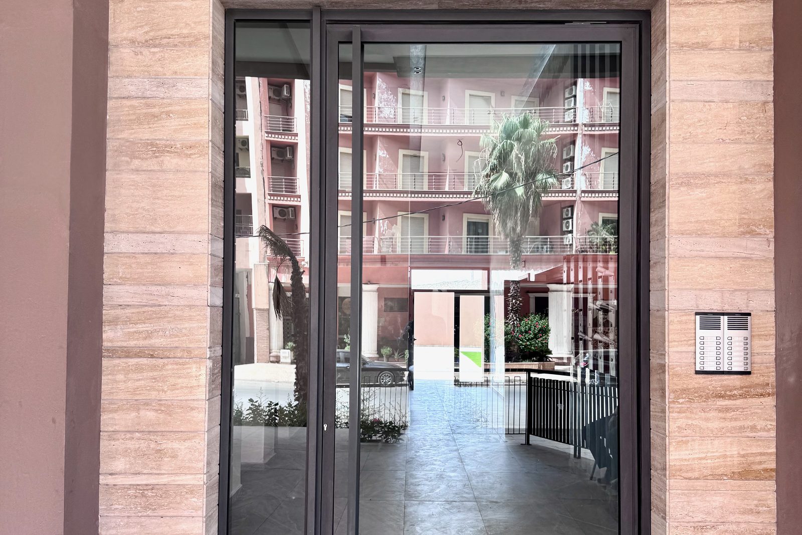 Entrée d'une résidence à Marrakech, porte vitrée donnant sur la cour intérieure