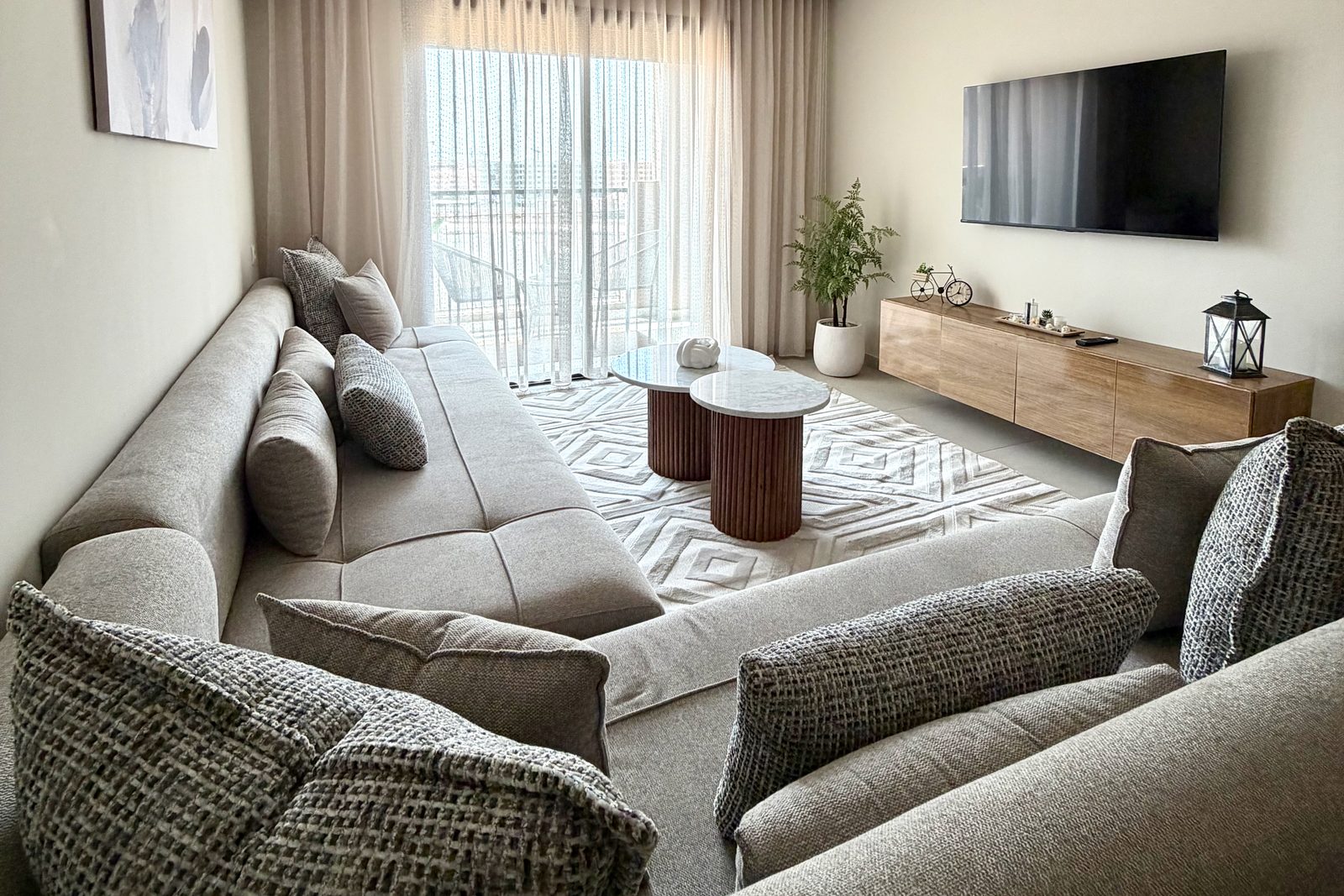 Salon d'un appartement en location courte durée à Marrakech, canapé d'angle et baie vitrée